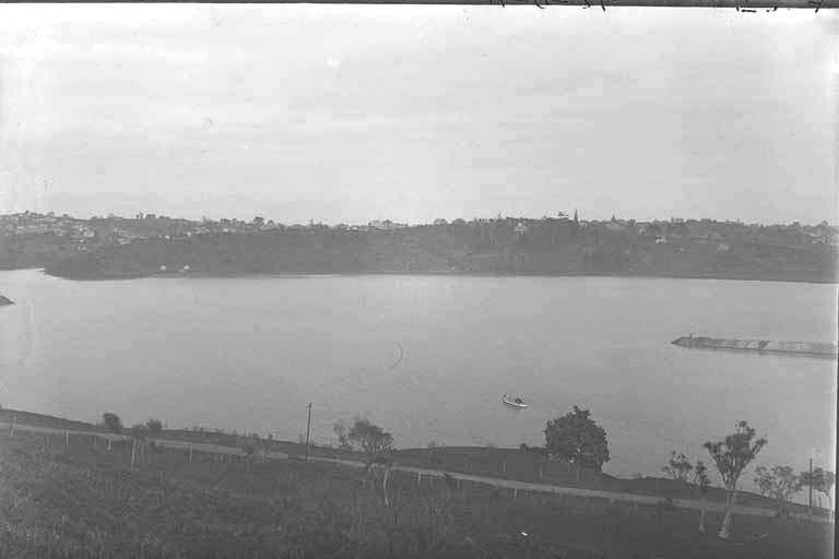 Looking south west over the Orakei Basin showing what is now Kepa Road (c. 1920)